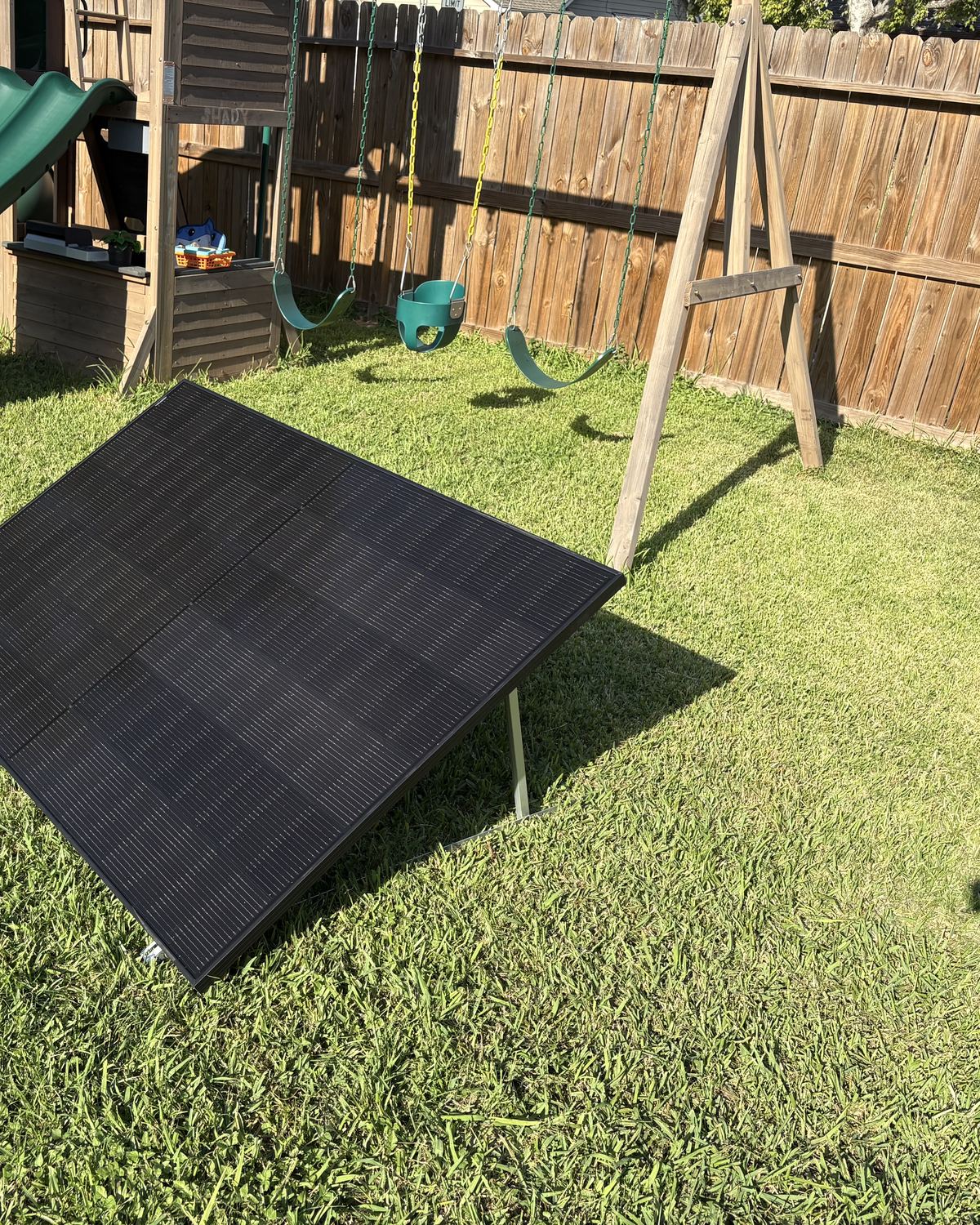 The kit set up on the grass in front of a wooden backyard fence
